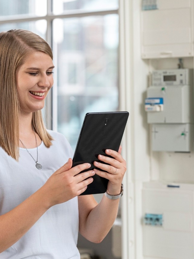 intelligentes Messystem, Frau mit Tablet und iMSys, smart meter, transparent, Kundenportal